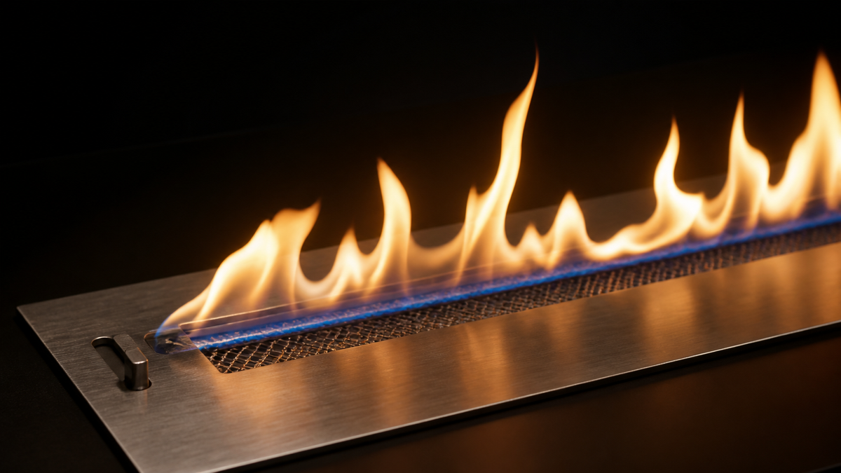 Brûleur inox d'une cheminée éthanol en gros plan, ligne de flamme continue sur fond noir